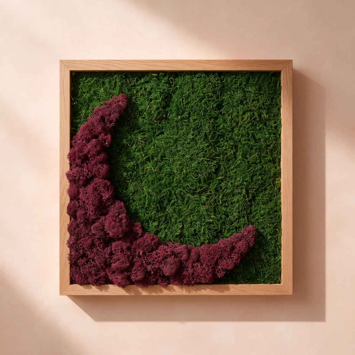 Una composición en tonos rojos y burdeos con texturas de musgo y liquen preservados, en un marco cuadrado de roble claro.