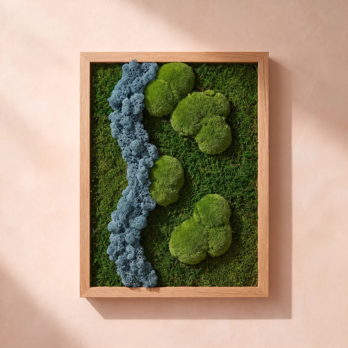 Una composición en tonos azules con texturas de musgo y liquen preservados, en un marco vertical de roble claro.
