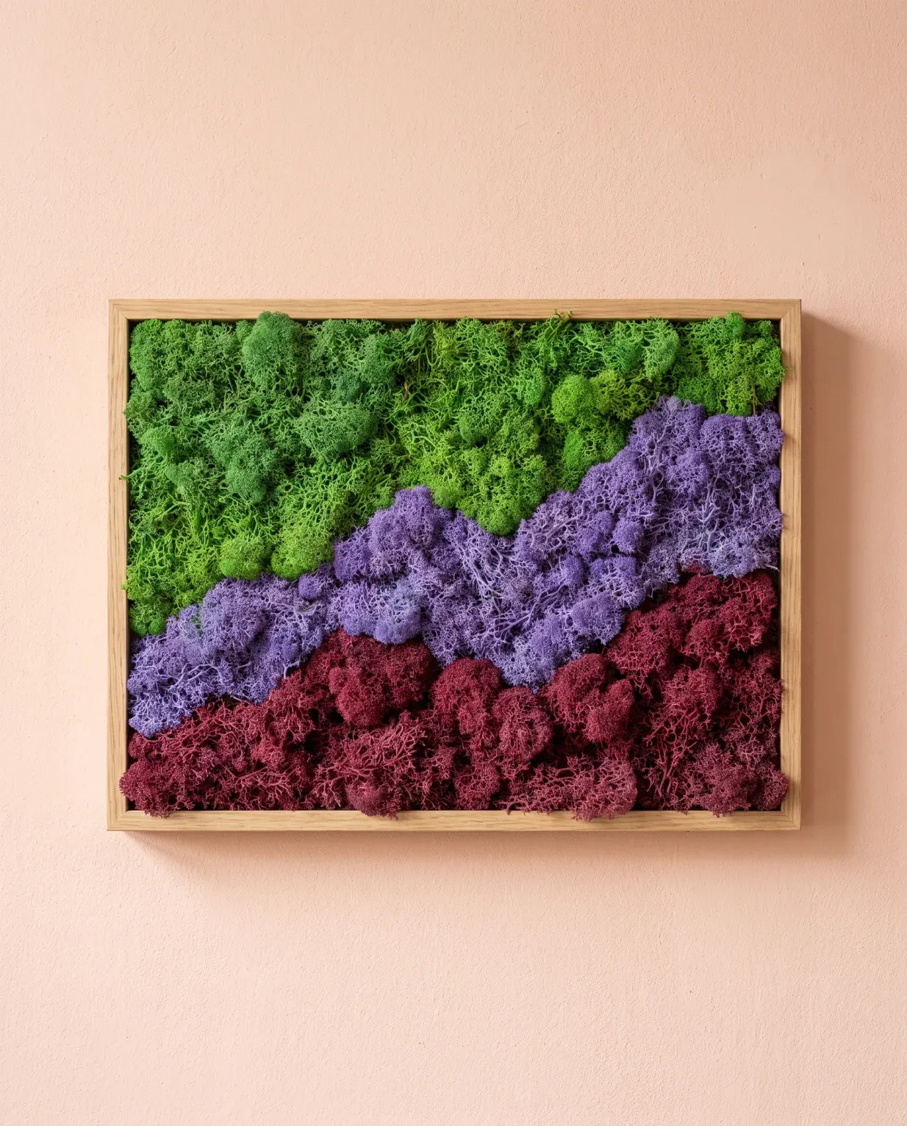 Bandas onduladas de liquen verde, violeta y granate evocan capas de montañas dentro de un marco de roble claro.