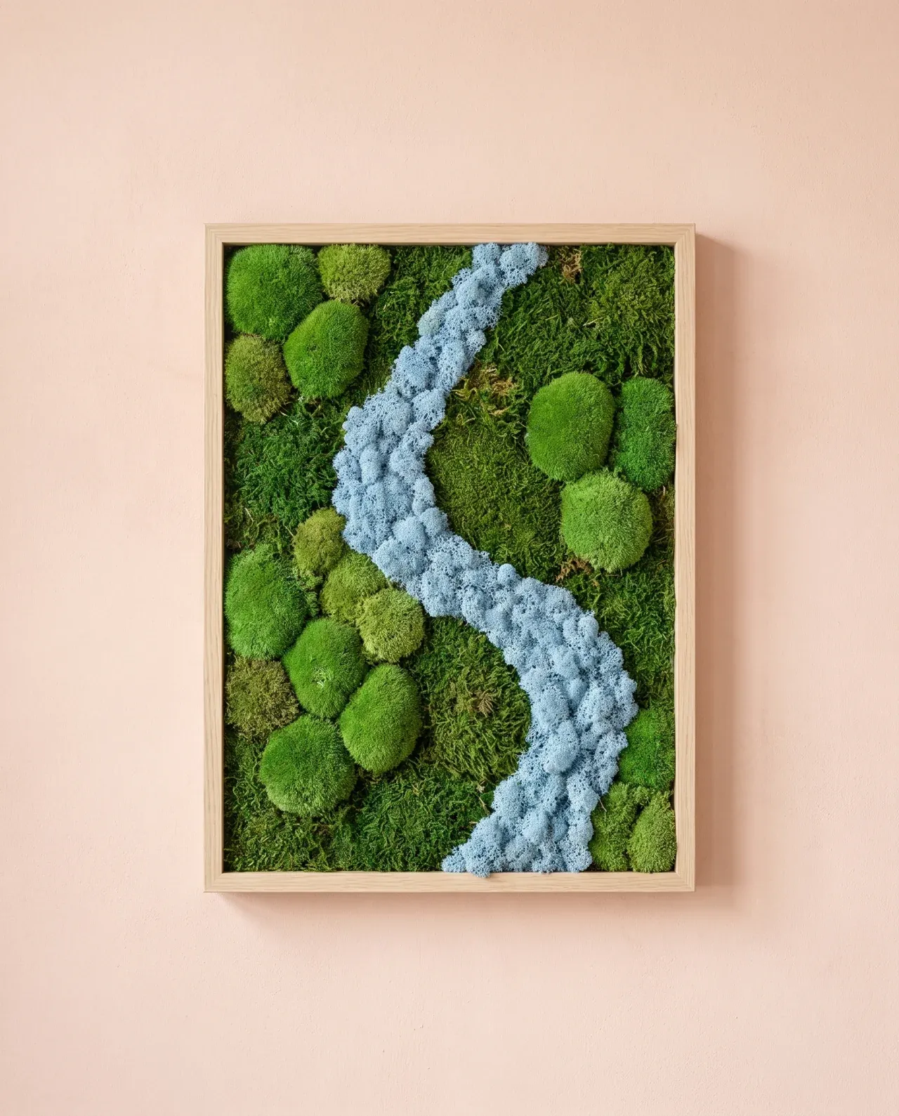 Una corriente de musgo azul claro recorre en diagonal un paisaje de cojines verdes, enmarcado en madera natural.