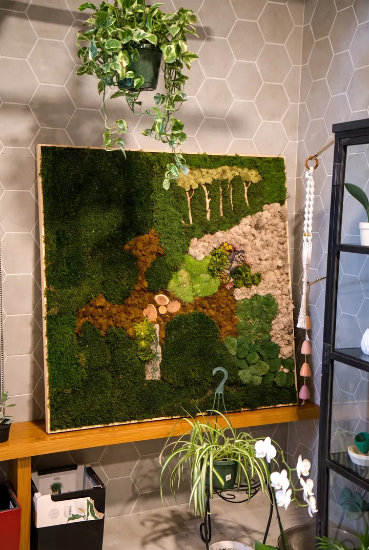 Musgo y pothos. Un cuadro de musgo con formas doradas y plantas colgantes.