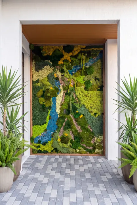 Un mural en la entrada. Musgo en azules y verdes, enmarcado en madera.