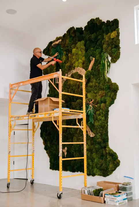 En altura, pieza a pieza. Instalando un muro de musgo desde el andamio.