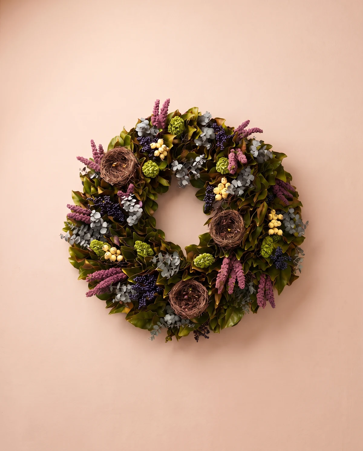 Una corona de tonos profundos, con follaje y pequeños detalles florales preservados.